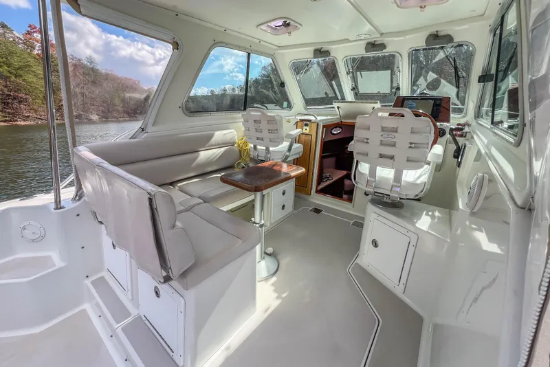 Slide: The Image of 2008 Back Cove 29 boat interior with seating, helm, and scenic lake view. - 22