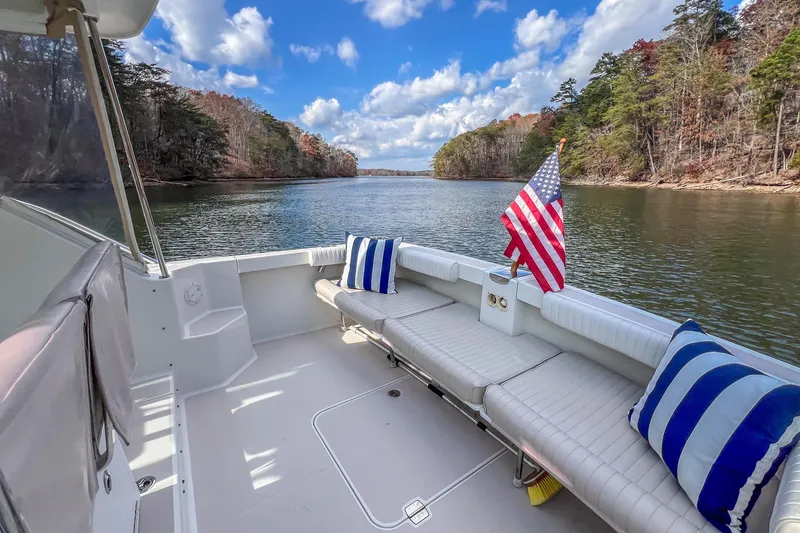 Slide: The Image of 2008 Back Cove 29 boat on a serene lake, featuring comfortable seating and an American flag. - 24
