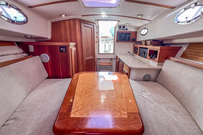 Slide: The Image of 2008 Back Cove 29 interior with wooden table, cushioned seating, and modern amenities. - 27