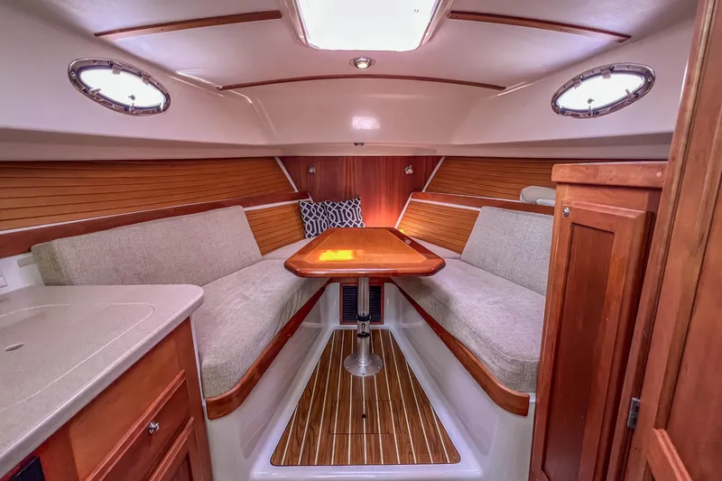 Slide: The Image of 2008 Back Cove 29 interior with cozy seating, wooden table, and elegant wood paneling. - 29