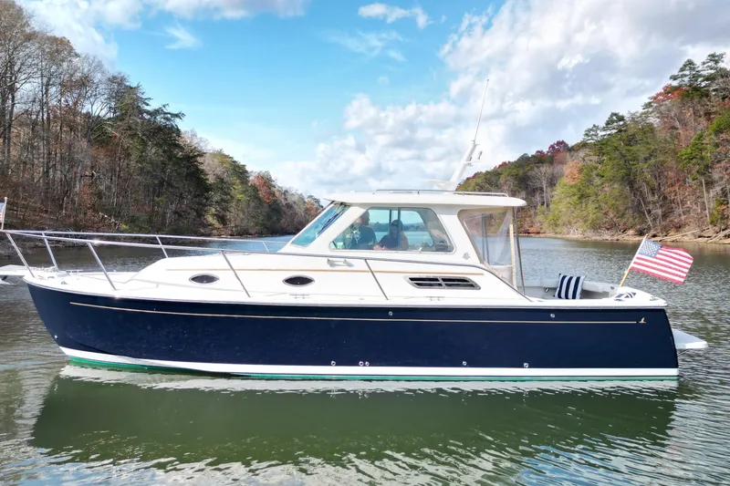 Slide: The Image of 2008 Back Cove 29 boat cruising on a lake with American flags. - 3