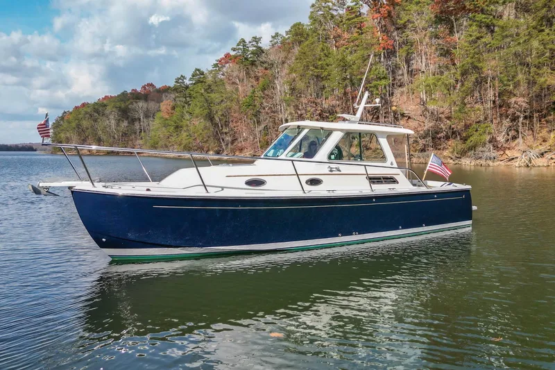 Slide: The Image of 2008 Back Cove 29 boat on a serene lake with forested shoreline. - 32