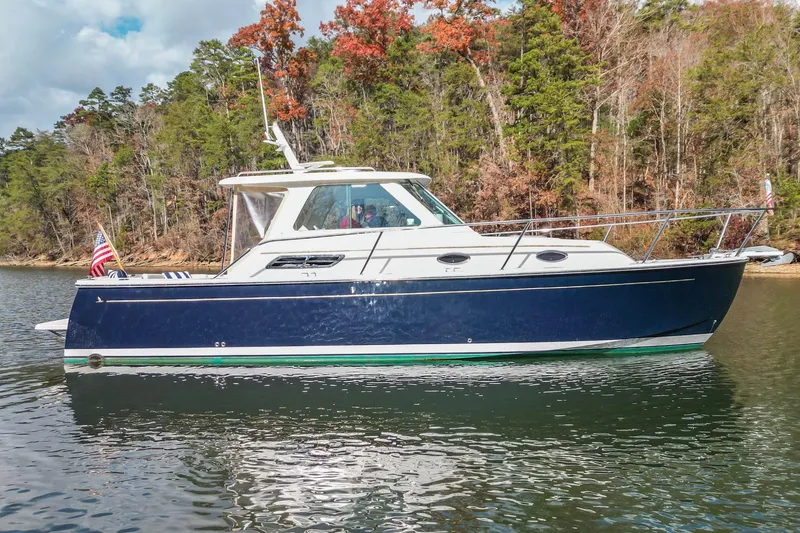 Slide: The Image of 2008 Back Cove 29 boat on a calm lake with forested shoreline. - 33