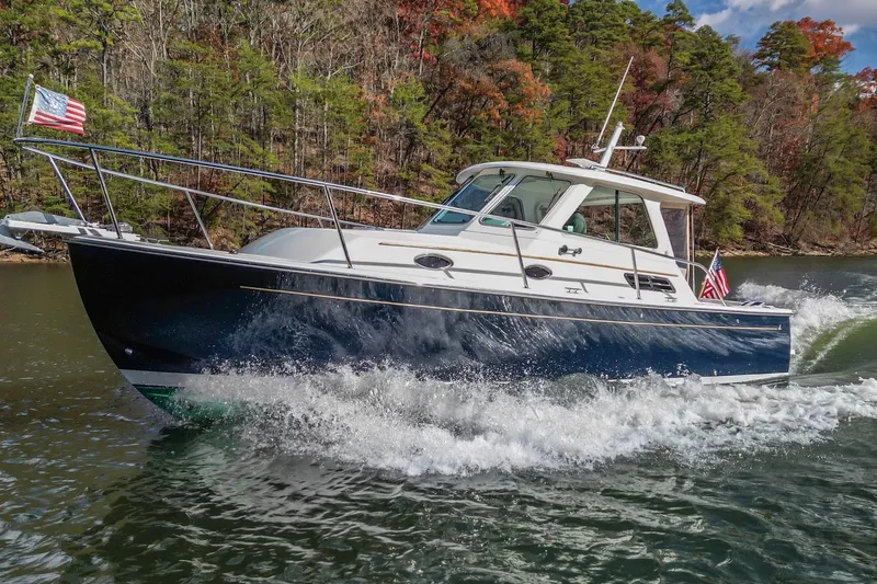 Slide: The Image of 2008 Back Cove 29 cruising on a scenic lake with American flags. - 35