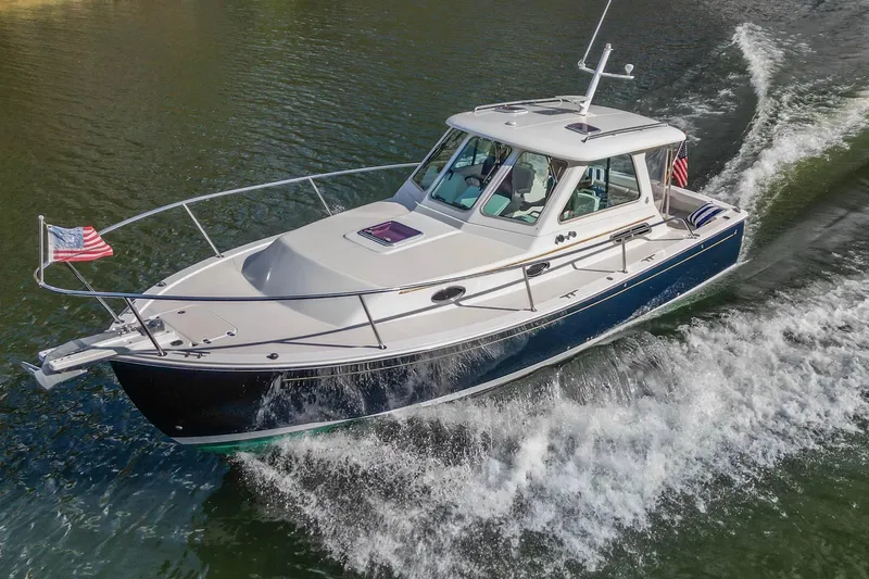 Slide: The Image of 2008 Back Cove 29 boat cruising on water with American flag. - 36