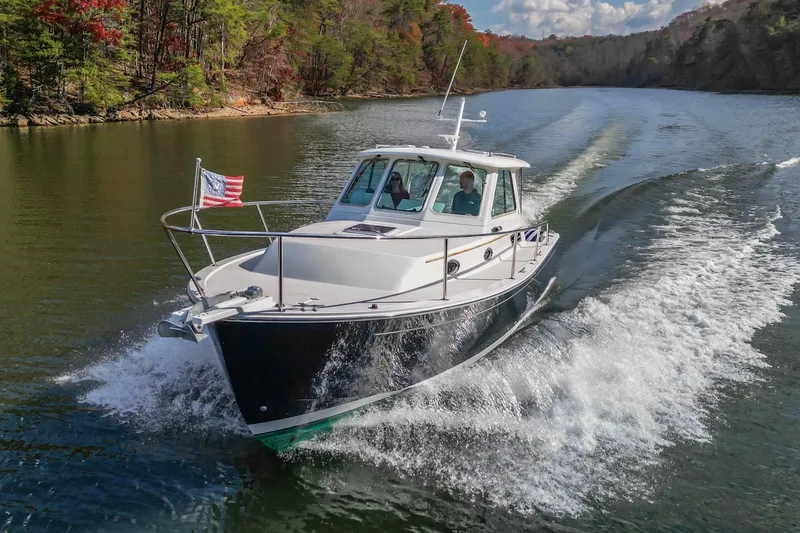 Slide: The Image of 2008 Back Cove 29 boat cruising on a scenic river with American flag. - 37