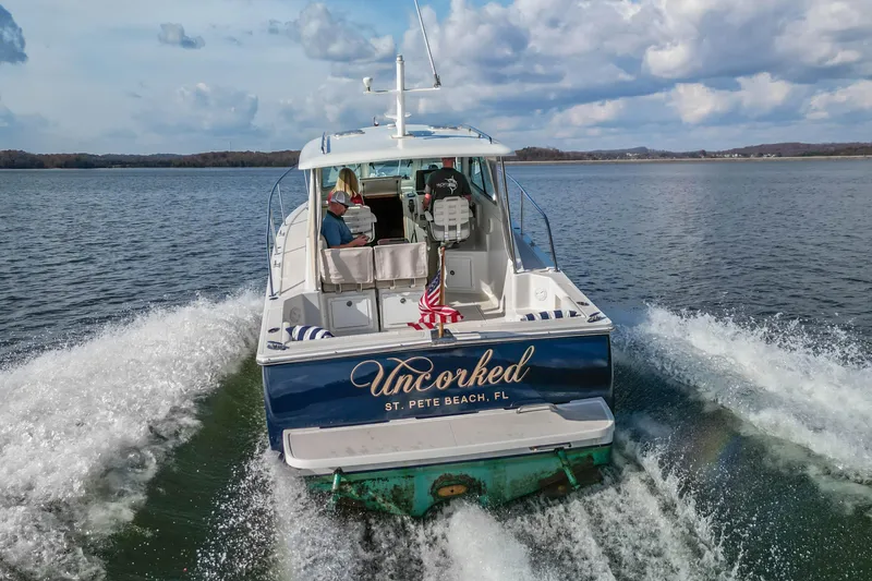 Slide: The Image of 2008 Back Cove 29 boat "Uncorked" cruising on a lake under a cloudy sky. - 7