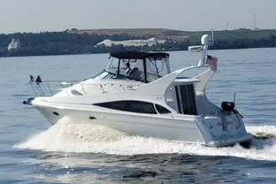 The Image of 2005 Carver 36 Mariner cruising on a calm lake with scenic background. - 0