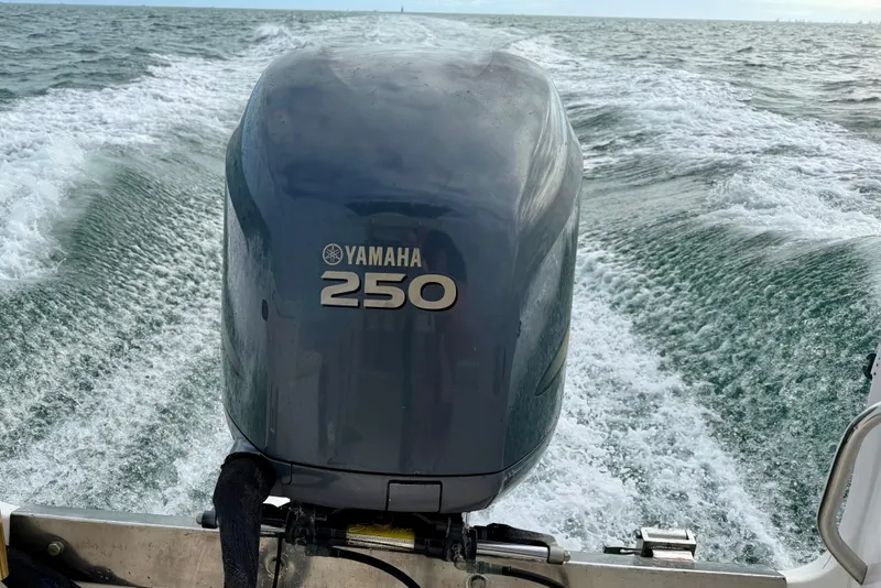 Slide: The Image of Yamaha 250 outboard motor on 2003 Custom 23 Center Console boat, ocean wake visible. - 2