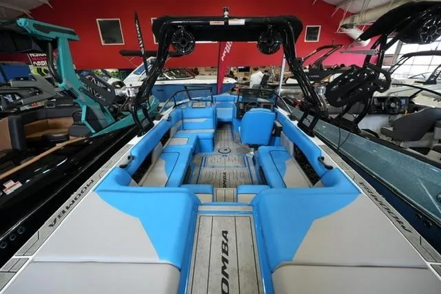 Slide: The Image of 2026 Moomba Mojo boat with blue and gray interior, showcased in a showroom. - 15