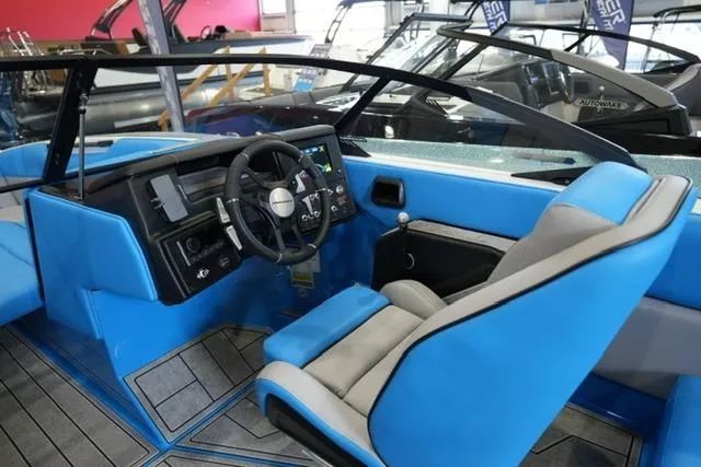 Slide: The Image of 2026 Moomba Mojo boat interior with blue and gray seating, modern dashboard, and steering wheel. - 20