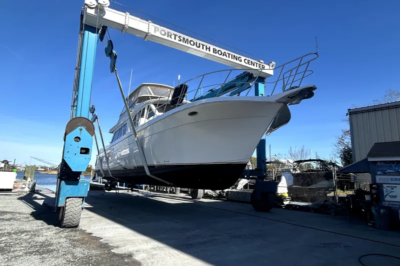 Slide: The Image of 1999 Navigator 5300 yacht lifted at Portsmouth Boating Center under clear blue sky. - 100