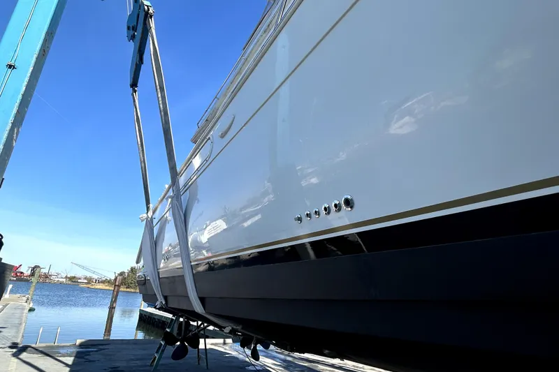 Slide: The Image of 1999 Navigator 5300 yacht being lifted at a marina under clear blue skies. - 101