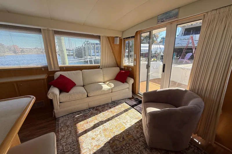 Slide: The Image of Cozy interior of a 1999 Navigator 5300 yacht with sofa, chair, and waterfront view. - 16