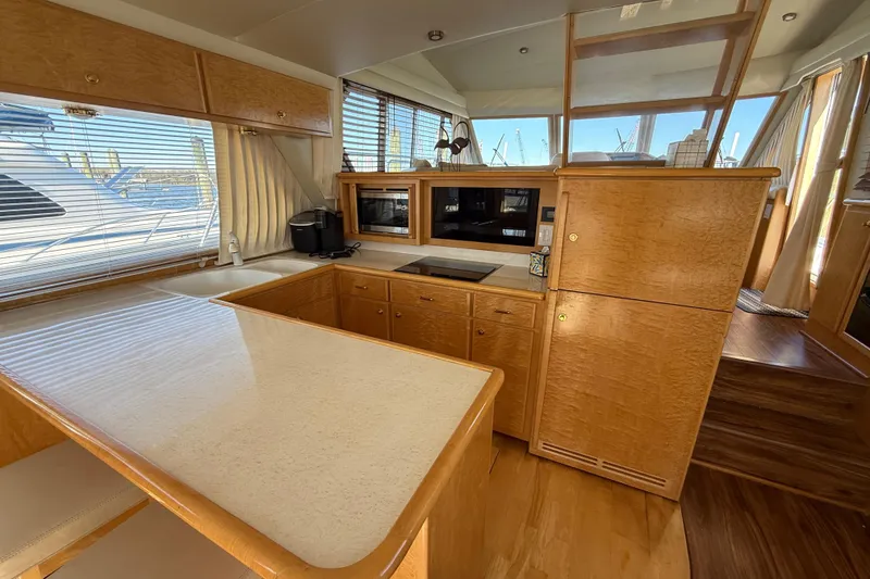 Slide: The Image of Luxurious 1999 Navigator 5300 yacht interior with modern kitchen and wooden cabinetry. - 20