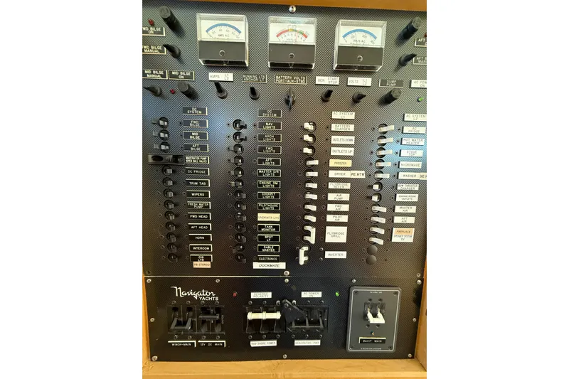 Slide: The Image of Electrical control panel of a 1999 Navigator 5300 yacht with various switches and gauges. - 24