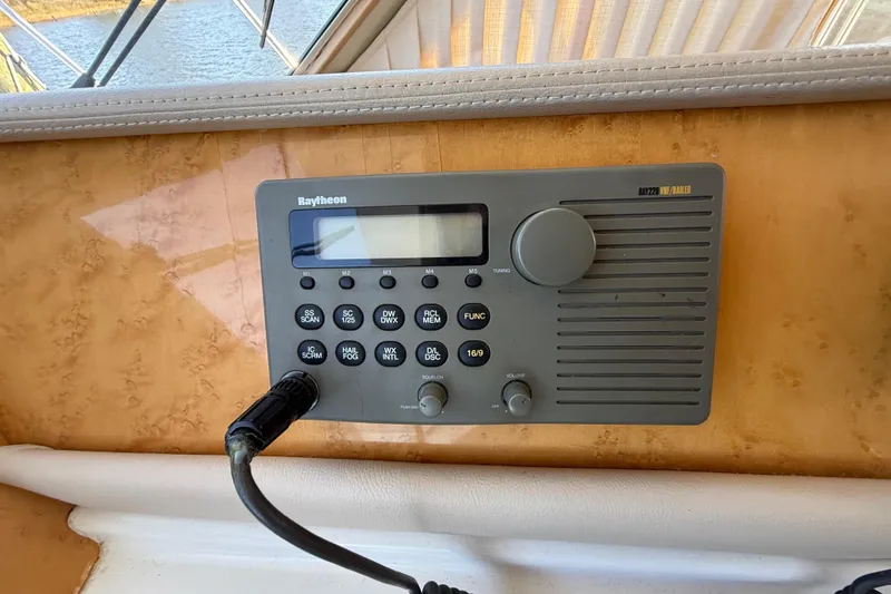 Slide: The Image of Raytheon marine radio on 1999 Navigator 5300 yacht dashboard, featuring control buttons and display. - 31