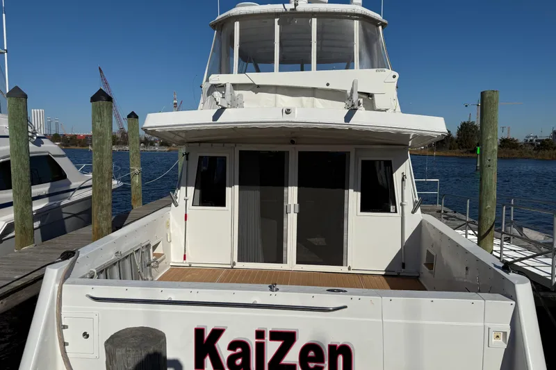 Slide: The Image of 1999 Navigator 5300 yacht docked at marina, rear view with "KaiZen" name. - 4