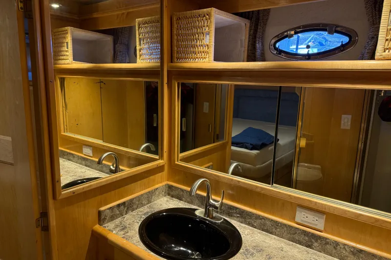 Slide: The Image of Luxurious bathroom interior of 1999 Navigator 5300 yacht with mirrored cabinets and black sink. - 46