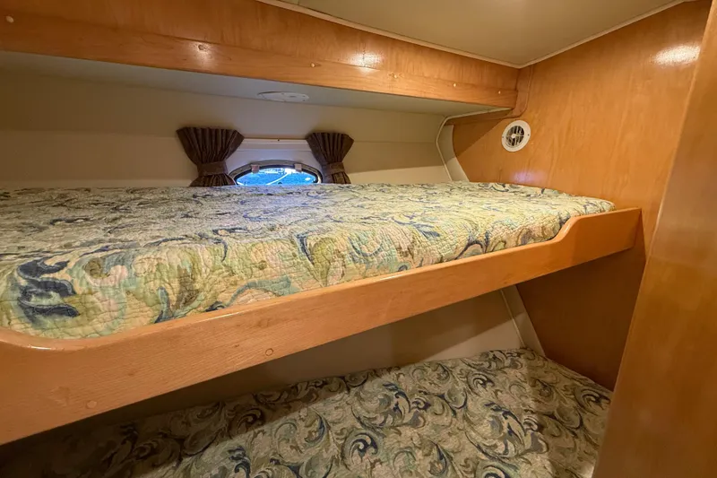 Slide: The Image of Bunk beds in 1999 Navigator 5300 yacht cabin with patterned bedding and wooden finish. - 57