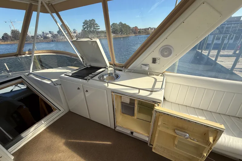Slide: The Image of 1999 Navigator 5300 yacht interior with kitchenette and seating, overlooking serene waterfront. - 63