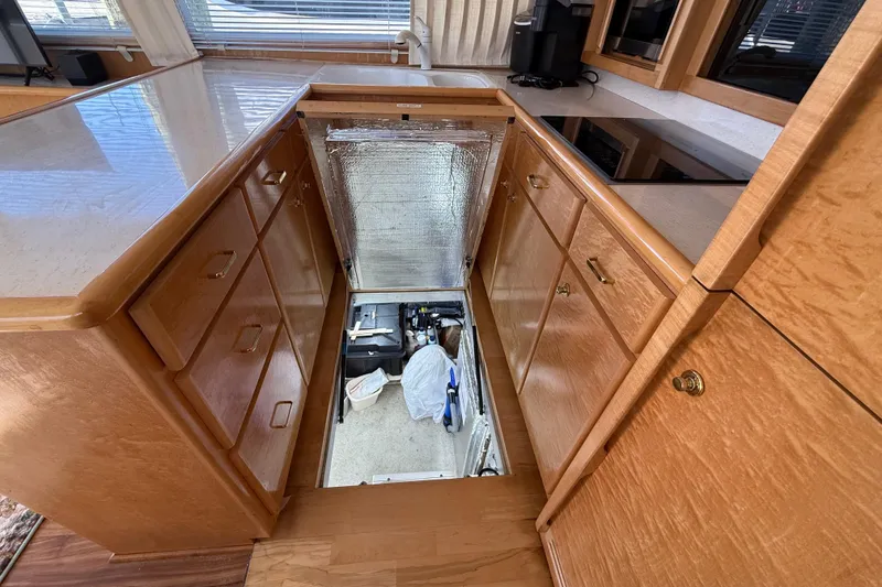 Slide: The Image of 1999 Navigator 5300 yacht kitchen with open floor storage, wooden cabinets, and modern appliances. - 70