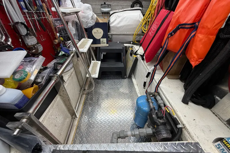 Slide: The Image of Storage area on a 1999 Navigator 5300 boat with tools, life jackets, and equipment. - 75