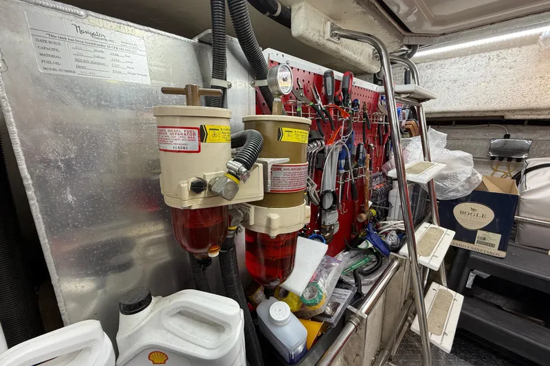 Slide: The Image of Engine room of 1999 Navigator 5300 with tools and fuel filters. - 77