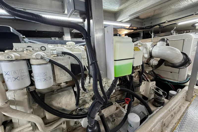 Slide: The Image of Engine room of a 1999 Navigator 5300 yacht, showcasing mechanical components and fluid containers. - 83