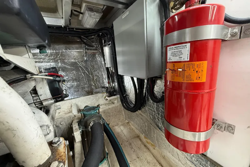 Slide: The Image of Engine room of 1999 Navigator 5300 with fire extinguisher and wiring. - 84
