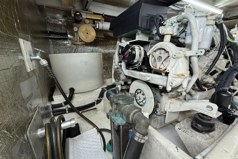 Slide: The Image of Engine room of a 1999 Navigator 5300 yacht, showcasing mechanical components and piping. - 87