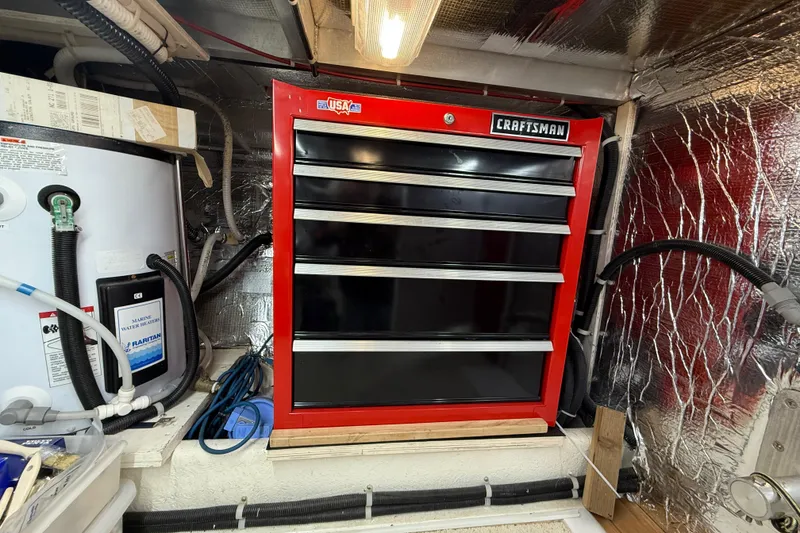 Slide: The Image of Red Craftsman tool chest in a 1999 Navigator 5300 engine room, next to marine water heater. - 90