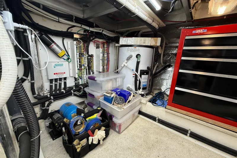 Slide: The Image of Engine room of 1999 Navigator 5300 with tools, wiring, and storage containers. - 91