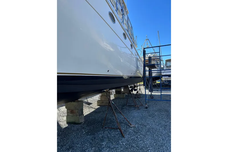Slide: The Image of 1999 Navigator 5300 yacht on stands, side view, under clear blue sky. - 94