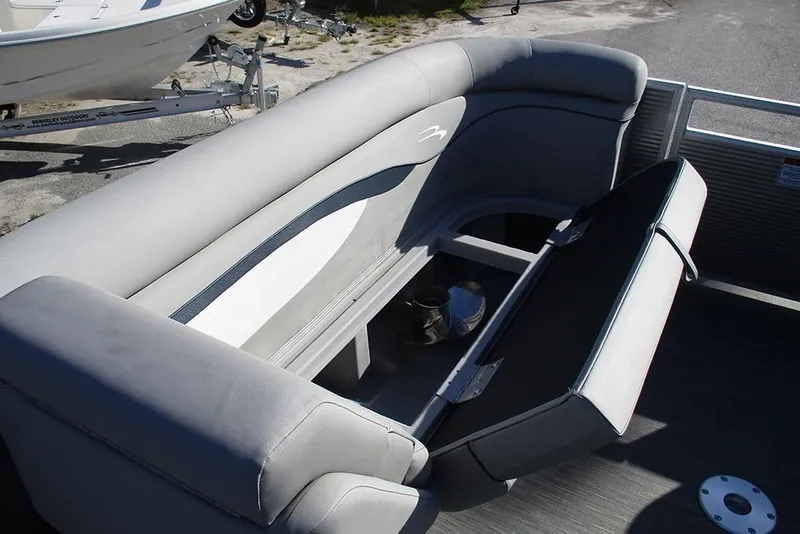 Slide: The Image of 2022 Bennington 20 SSR pontoon boat with open storage compartment and gray seating. - 14