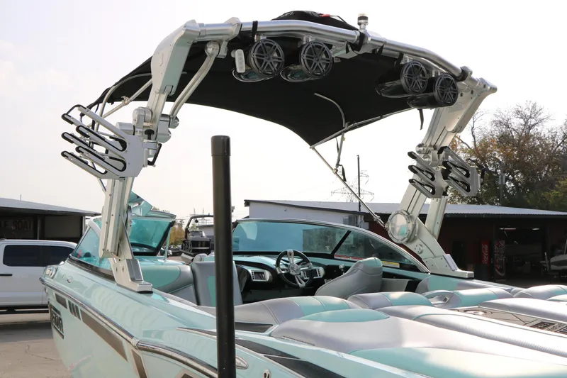 Slide: The Image of 2014 Master Craft X-Star boat with wakeboard tower and speakers, parked outdoors. - 13