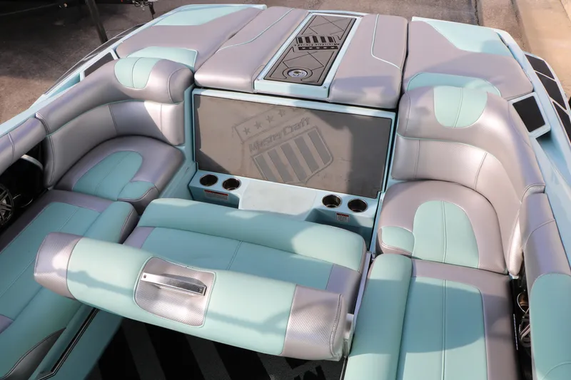 Slide: The Image of 2014 Master Craft X-Star boat interior with aqua and gray seating, cup holders, and logo. - 29