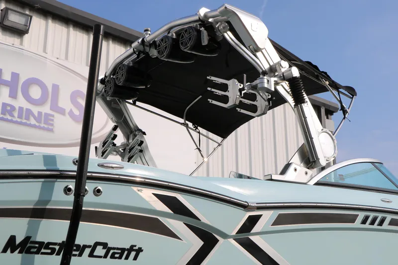 Slide: The Image of 2014 Master Craft X-Star boat with tower and speakers, displayed at a marine facility. - 3