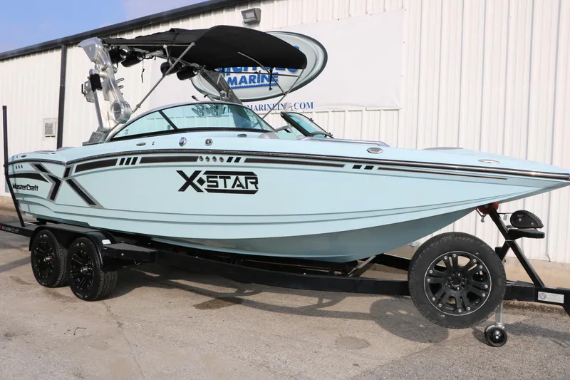 Slide: The Image of 2014 Master Craft X-Star boat on trailer, light blue with black accents, parked outdoors. - 4
