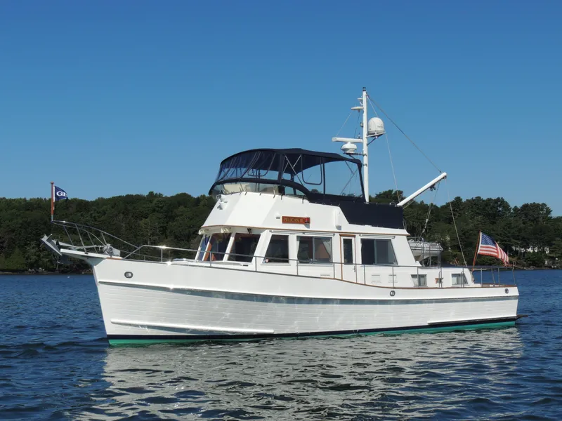 Slide: The Image of 2002 Grand Banks 42 Classic yacht on calm water, blue sky background. - 13