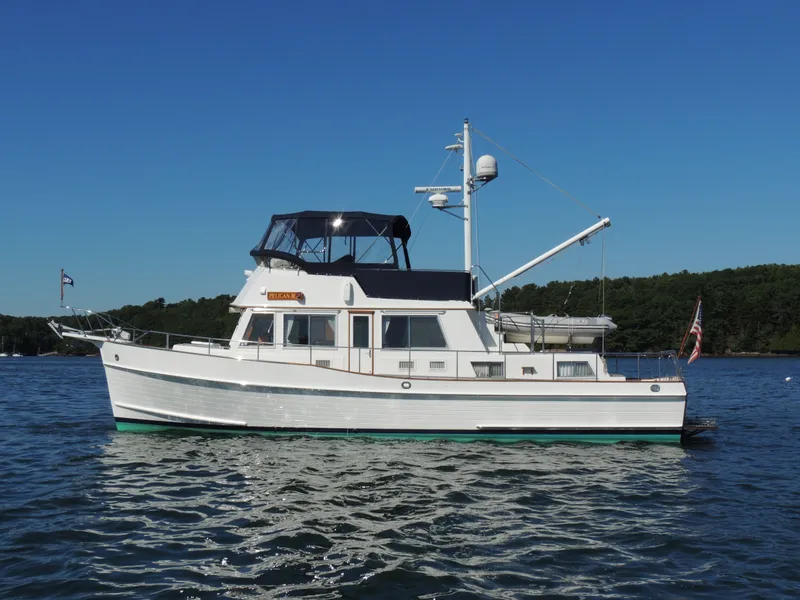 Slide: The Image of 2002 Grand Banks 42 Classic yacht on calm water, clear blue sky background. - 14