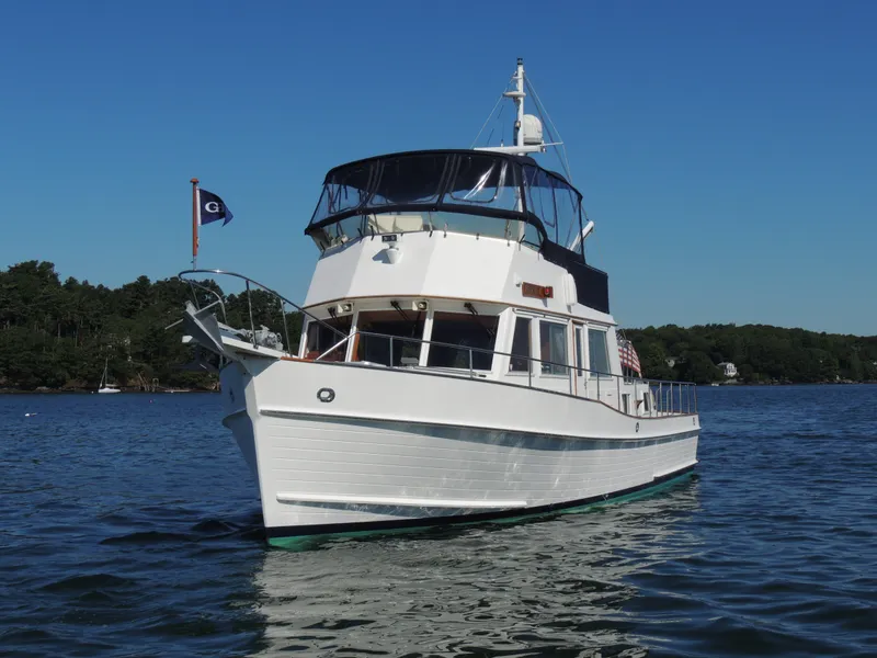 Slide: The Image of 2002 Grand Banks 42 Classic yacht on calm water, clear sky background. - 16