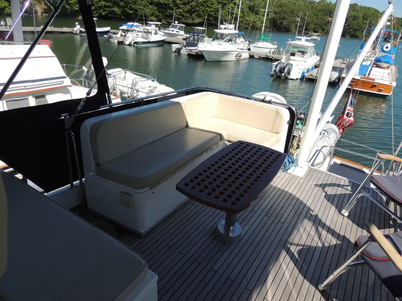Slide: The Image of Grand Banks 42 Classic 2002 yacht deck with seating and table, overlooking marina. - 35