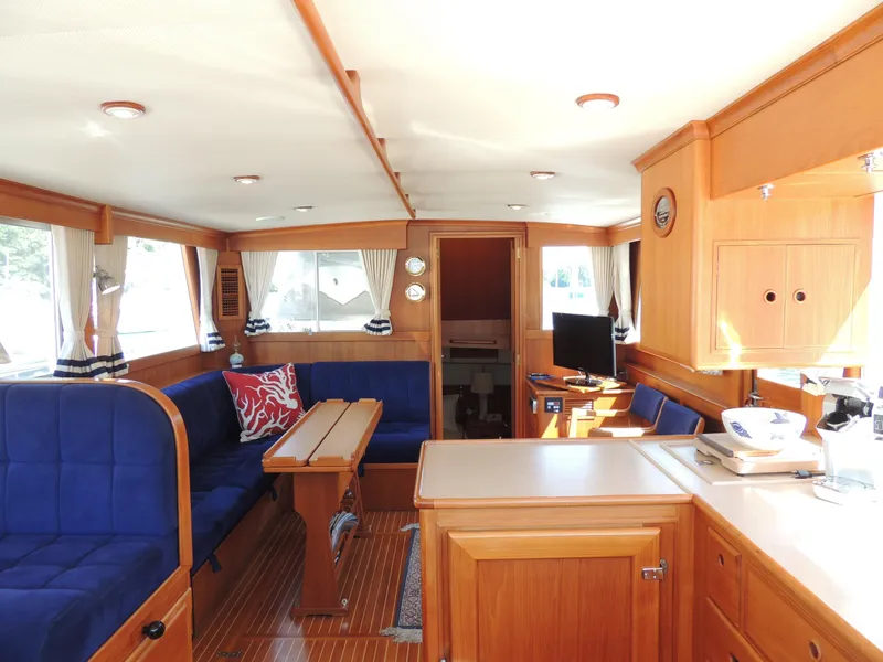 Slide: The Image of Interior of 2002 Grand Banks 42 Classic yacht with wooden furnishings and blue seating. - 37