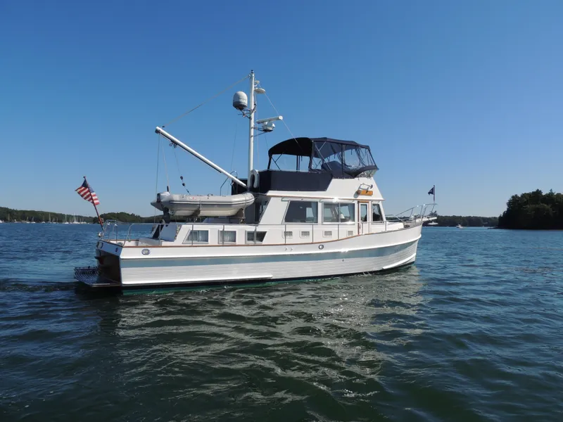 Slide: The Image of 2002 Grand Banks 42 Classic yacht on calm water under clear blue sky. - 7