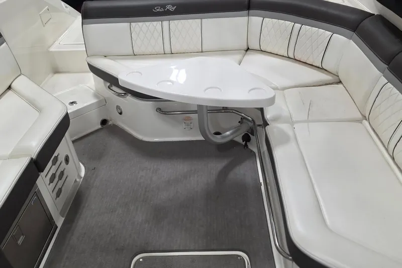 Slide: The Image of Interior seating of 2017 Sea Ray SLX 280 boat with white upholstery and table. - 1