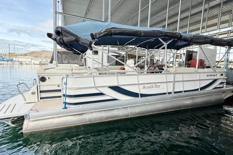 Slide: The Image of 2007 South Bay 925CR TT I/O pontoon boat docked under a covered marina. - 4