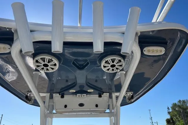 Slide: The Image of 2018 Tidewater 252 CC Adventure boat with rod holders and speakers under a clear blue sky. - 5