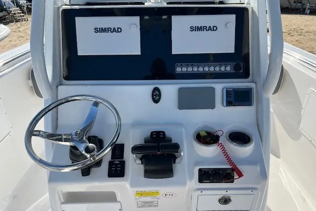 Slide: The Image of 2018 Tidewater 252 CC Adventure boat console with dual Simrad displays and steering wheel. - 6