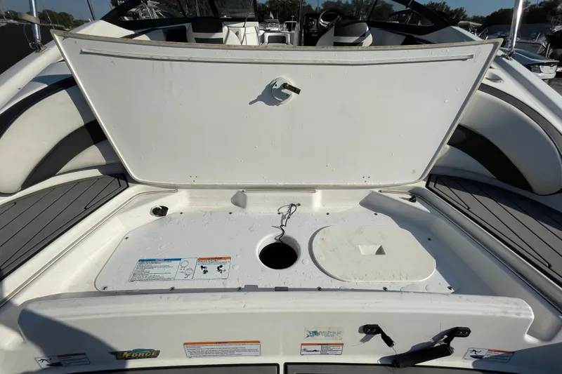 Slide: The Image of 2019 Yamaha Boats SX195 interior with seating and canopy, parked at a dealership. - 14